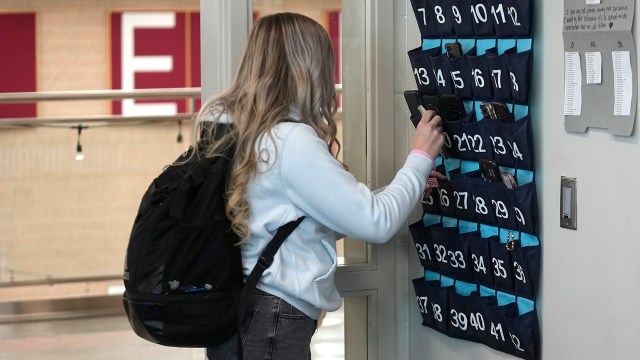 A ninth grader stores her cellphone in a holder as she enters class in Delta, Utah, on Feb. 23, 2024. (Rick Bowmer/AP Photo via Getty Images)